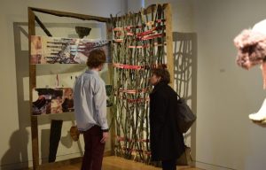 An artist discusses a sculpture with an observer.