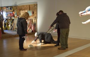 A group of people stand around a sculpture.