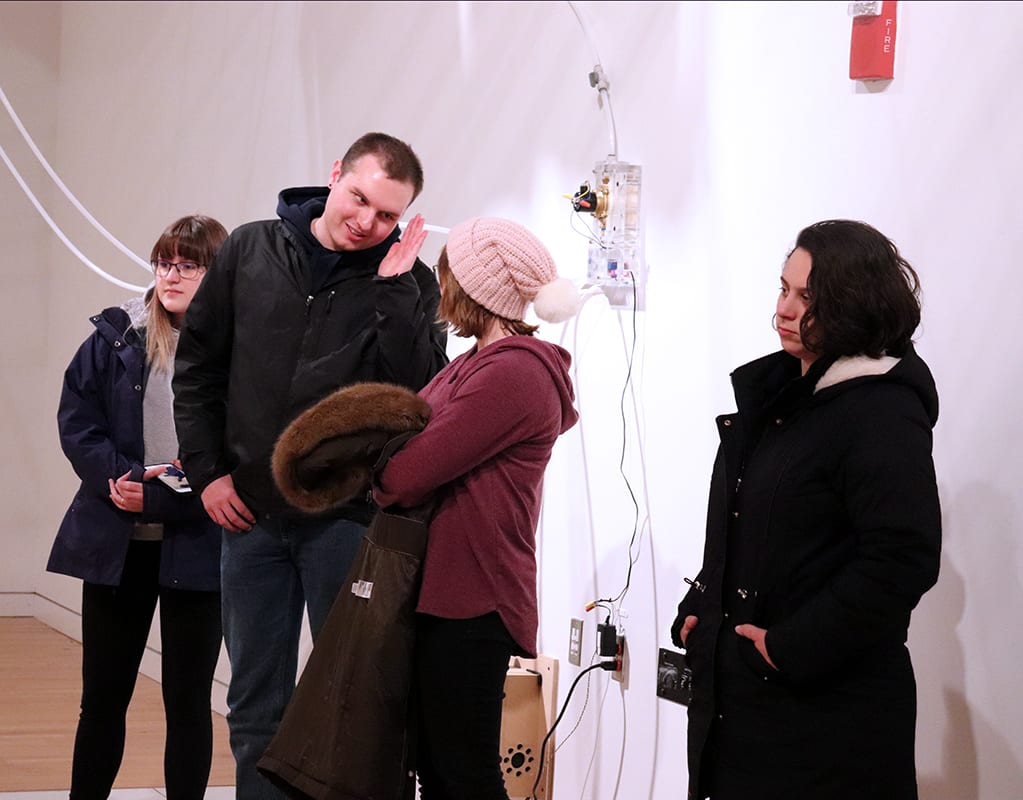 Students attend the opening of John Umphlett's Elements of Degradation.