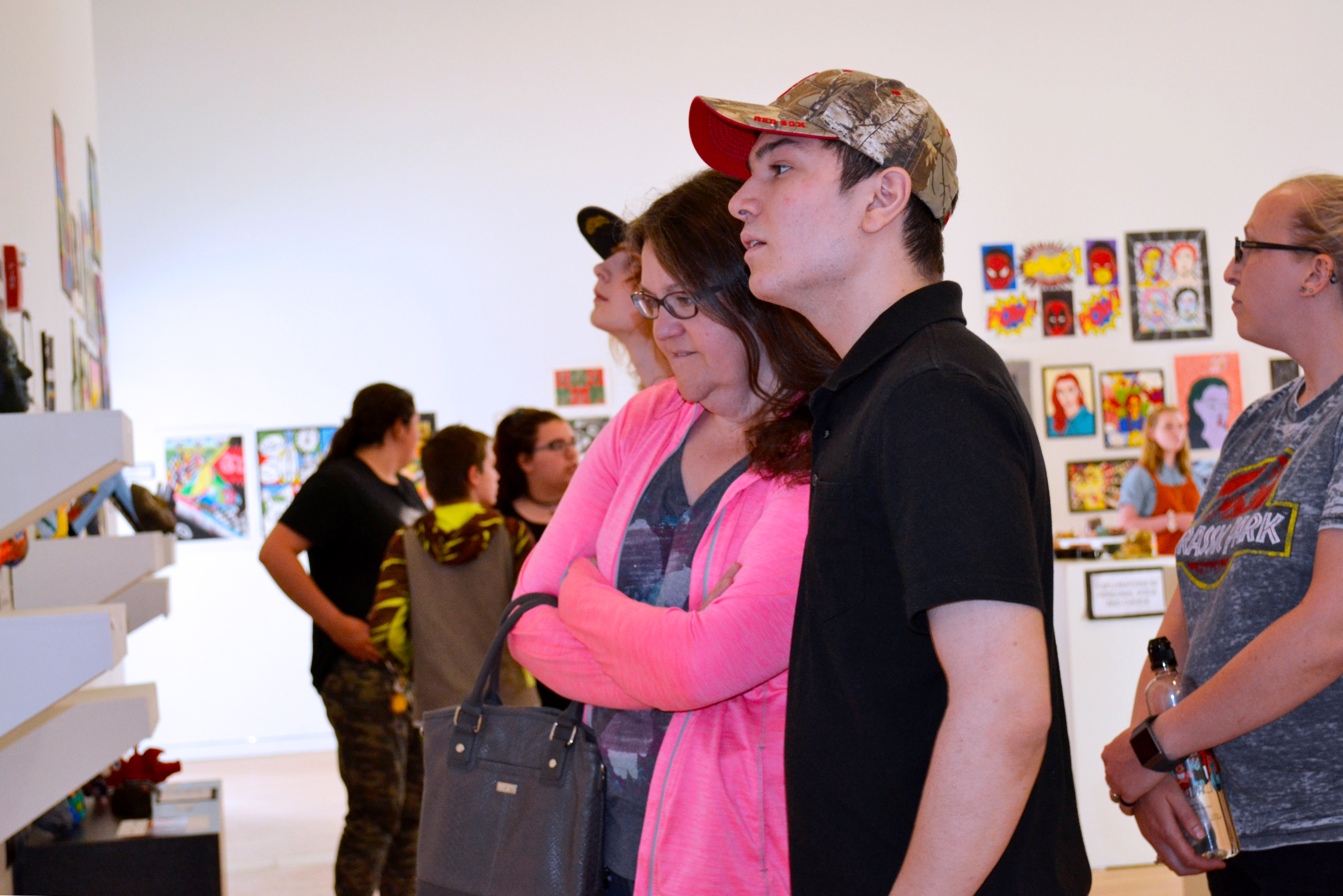 A mother and son observe a gallery wall.