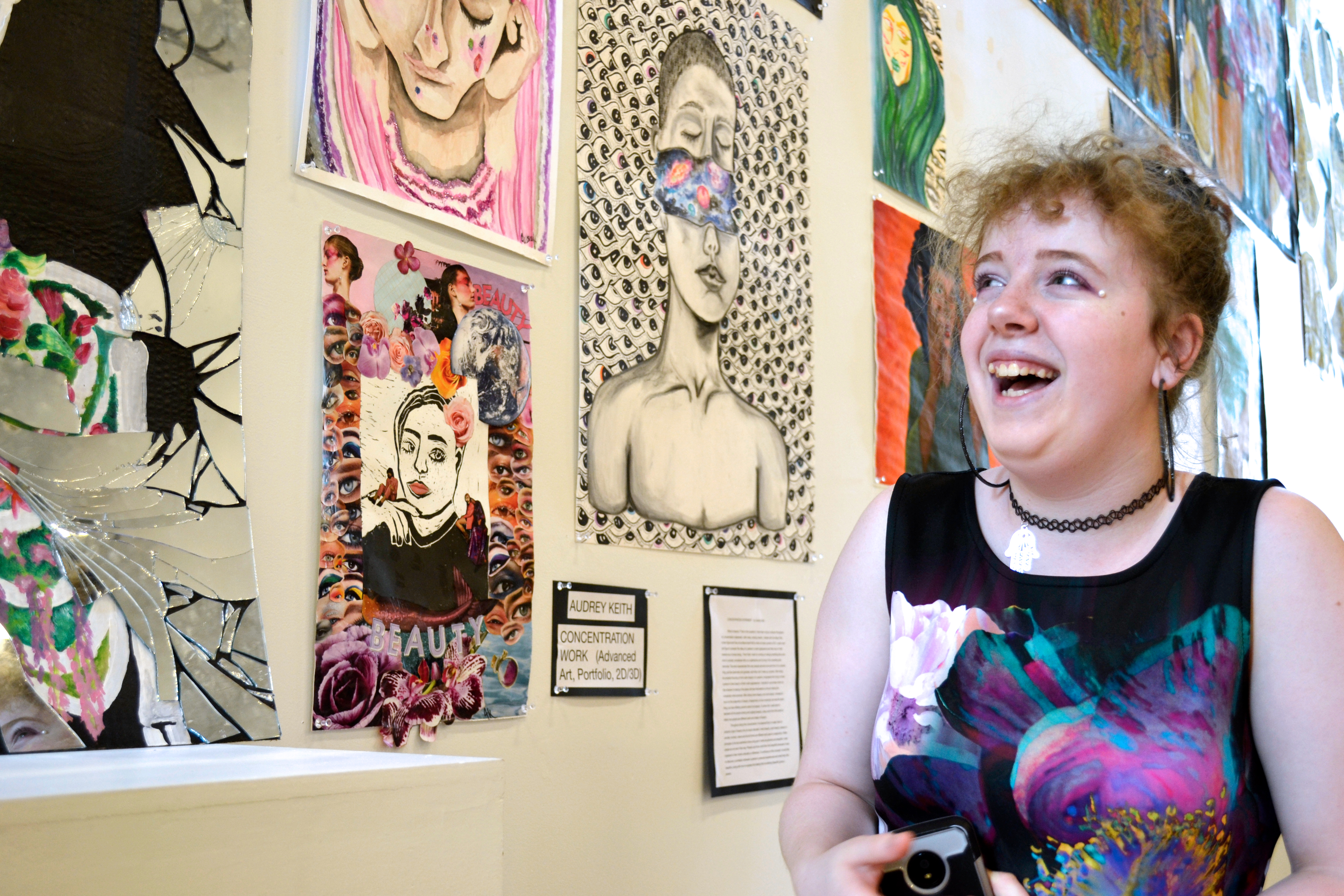 An artist explains her artwork excitedly to the camera person.
