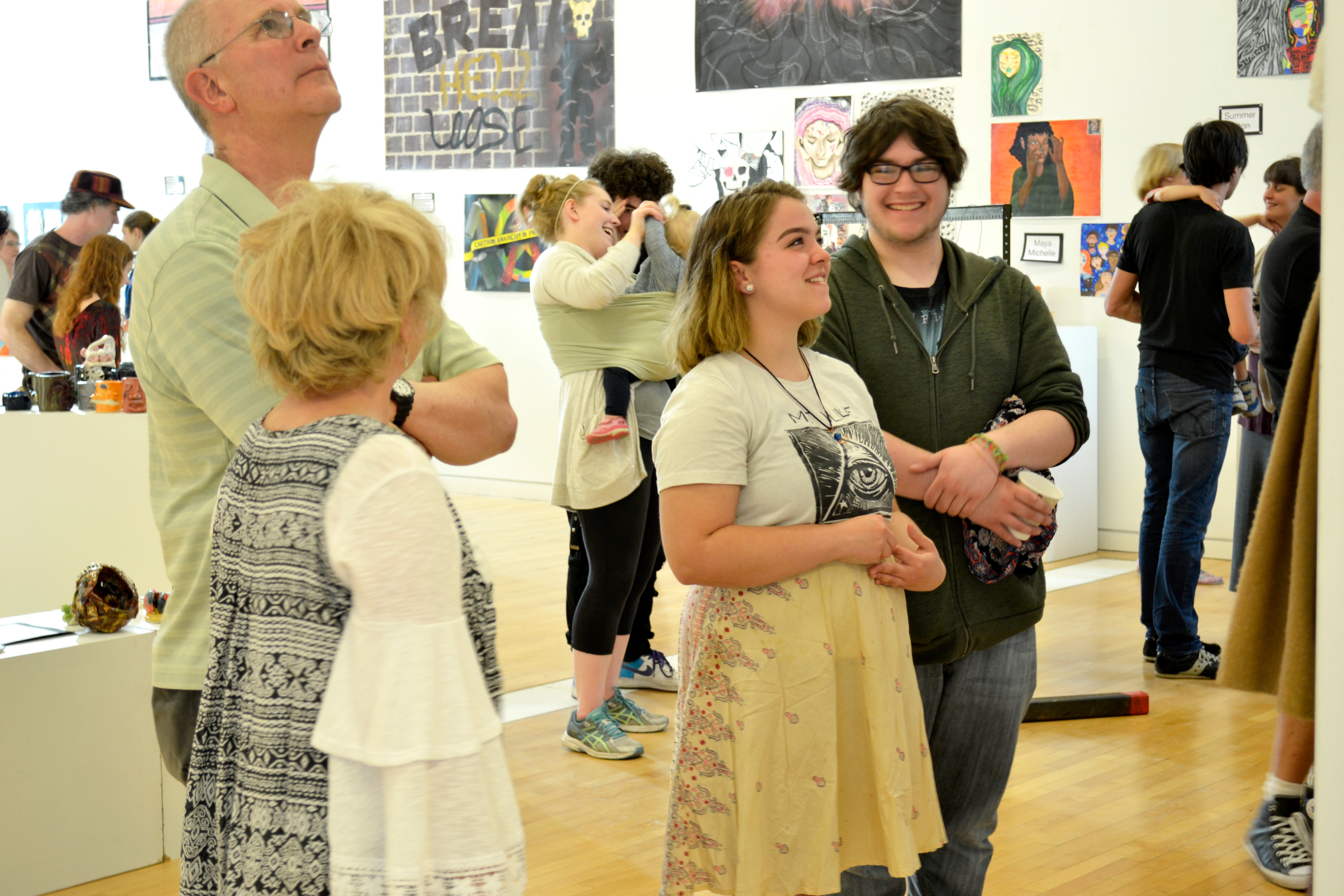 A group of people smile as they view artwork.
