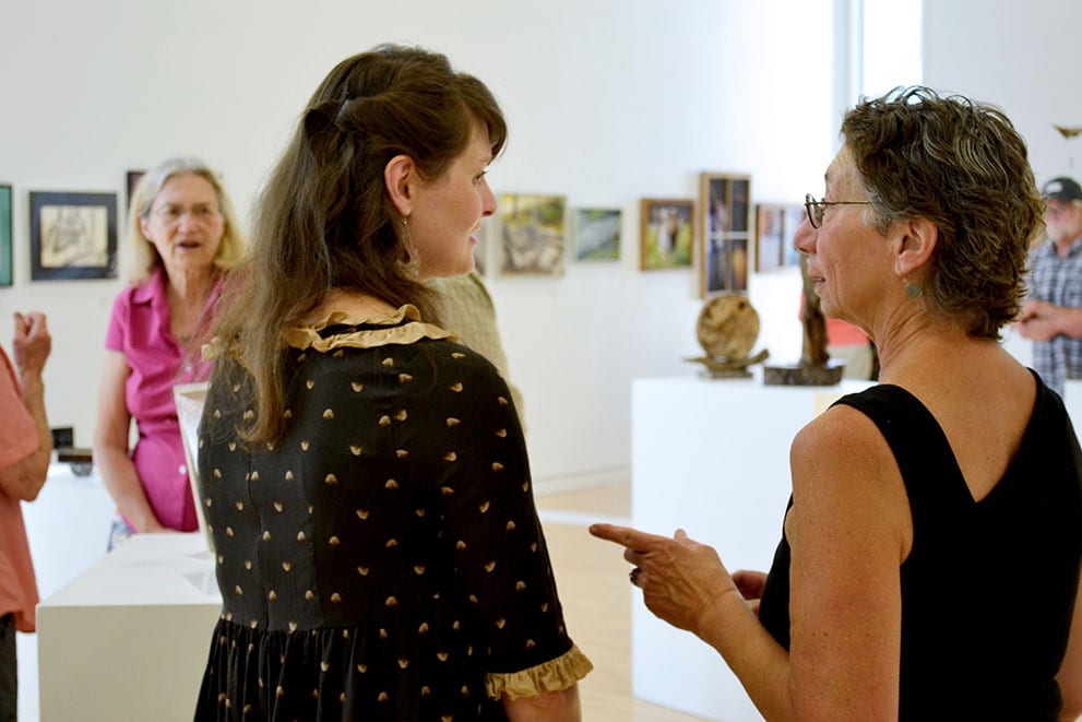 Emery director Ann Bartges speaks with one of the featured artists.
