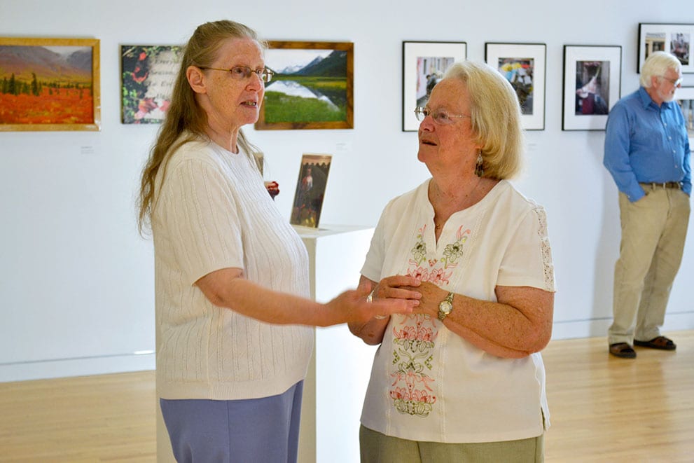 An artist discusses the gallery with a friend.