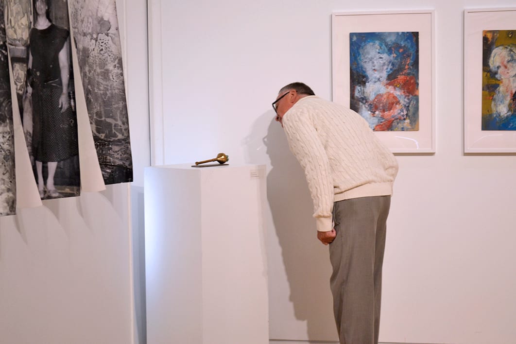 A man peers over a sculpture.