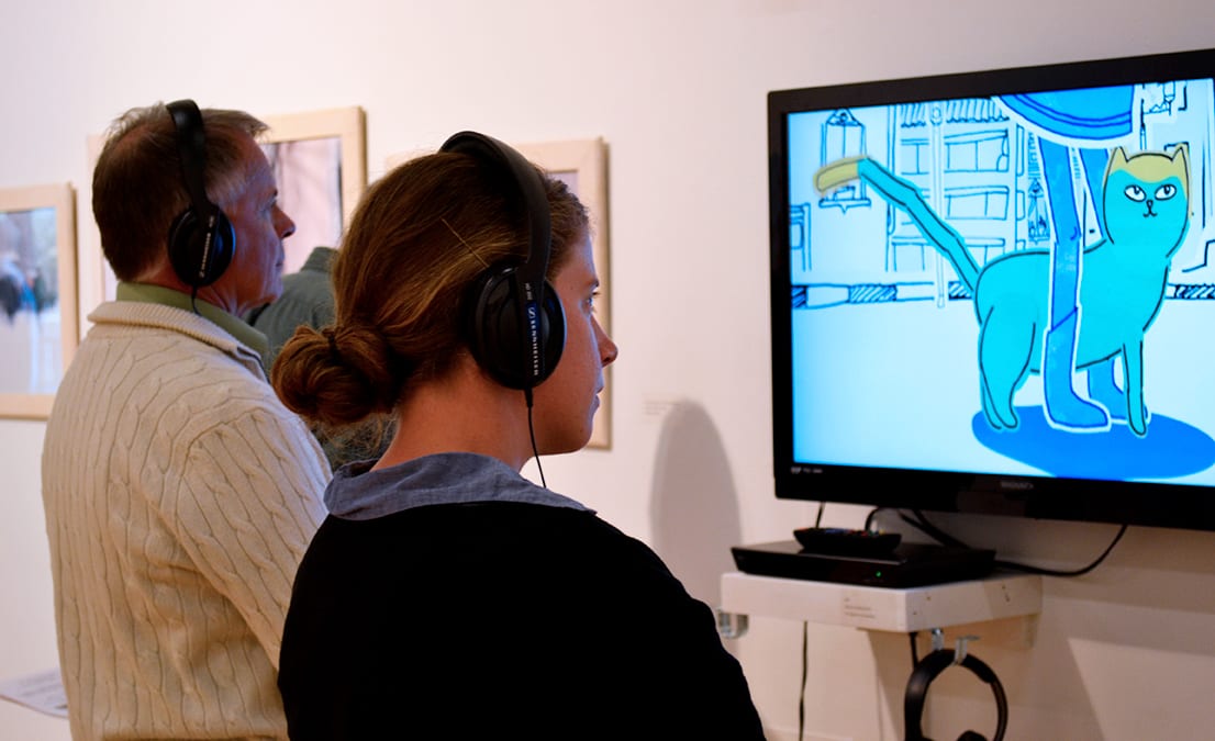 Visitors observe artwork from the exhibition.