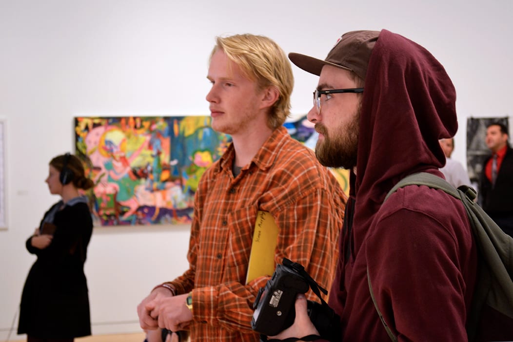 Students observe artwork from the exhibition.