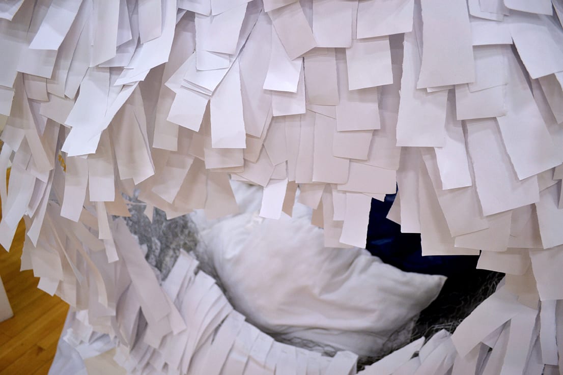 A nest is formed from paper and wire.