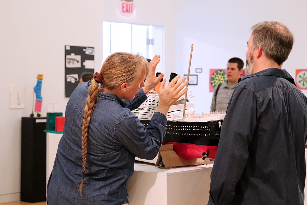 Patrons observe the artwork during the MBHS Opening Reception.