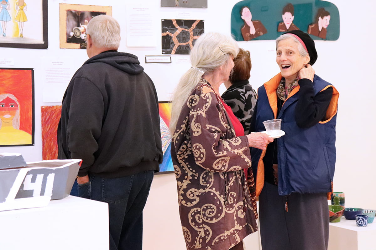 Patrons discuss artwork at the MBHS opening reception.