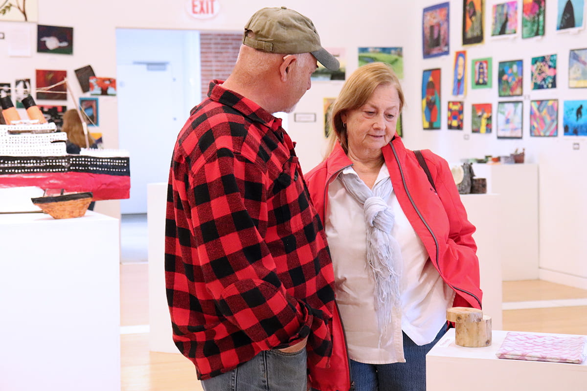 Patrons observe the artwork during the MBHS Opening Reception.