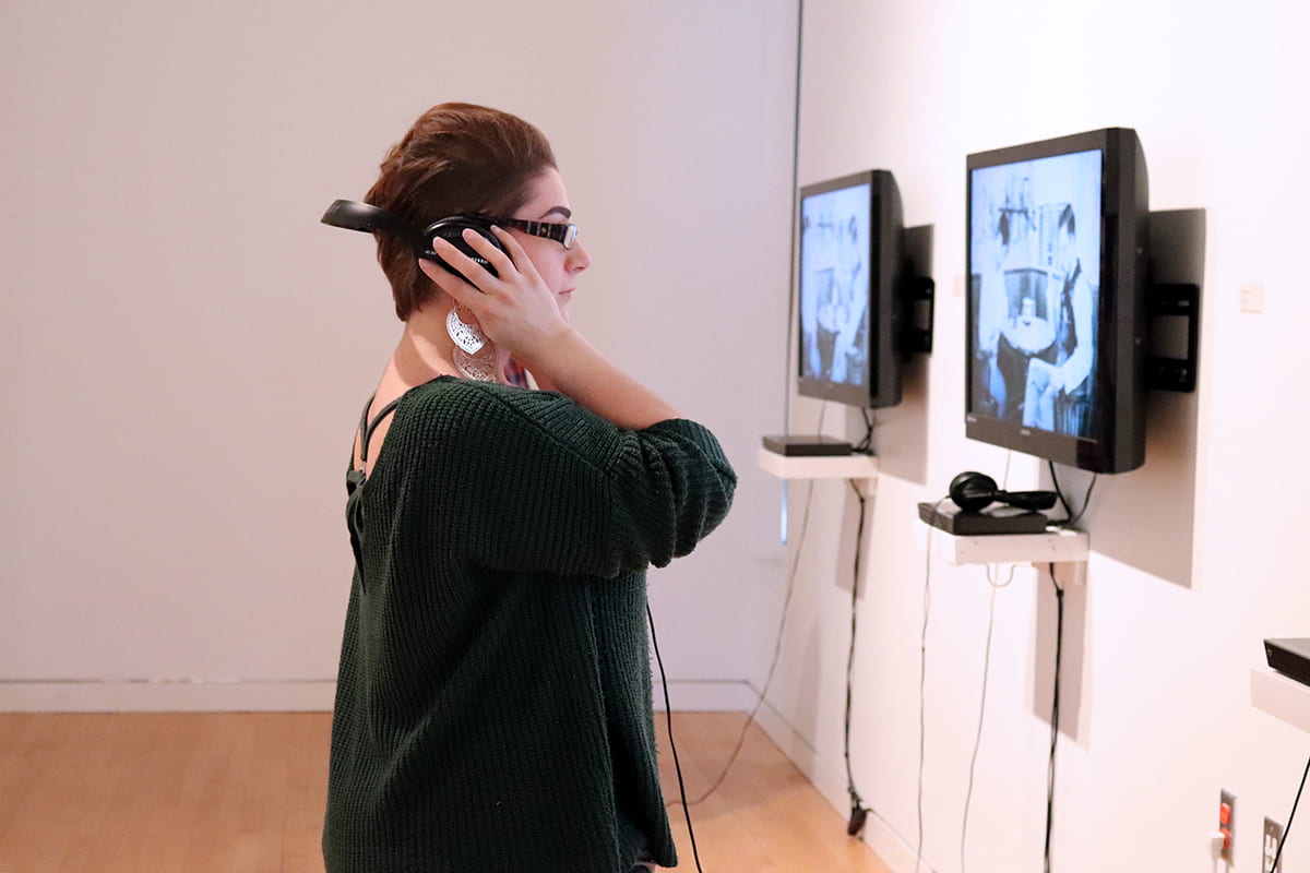 An artist observes their collaborator's art work.