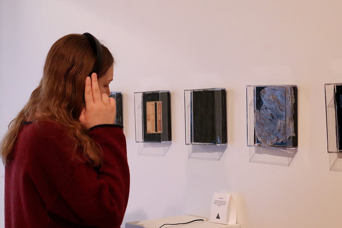 A visitor listens to an audio piece.