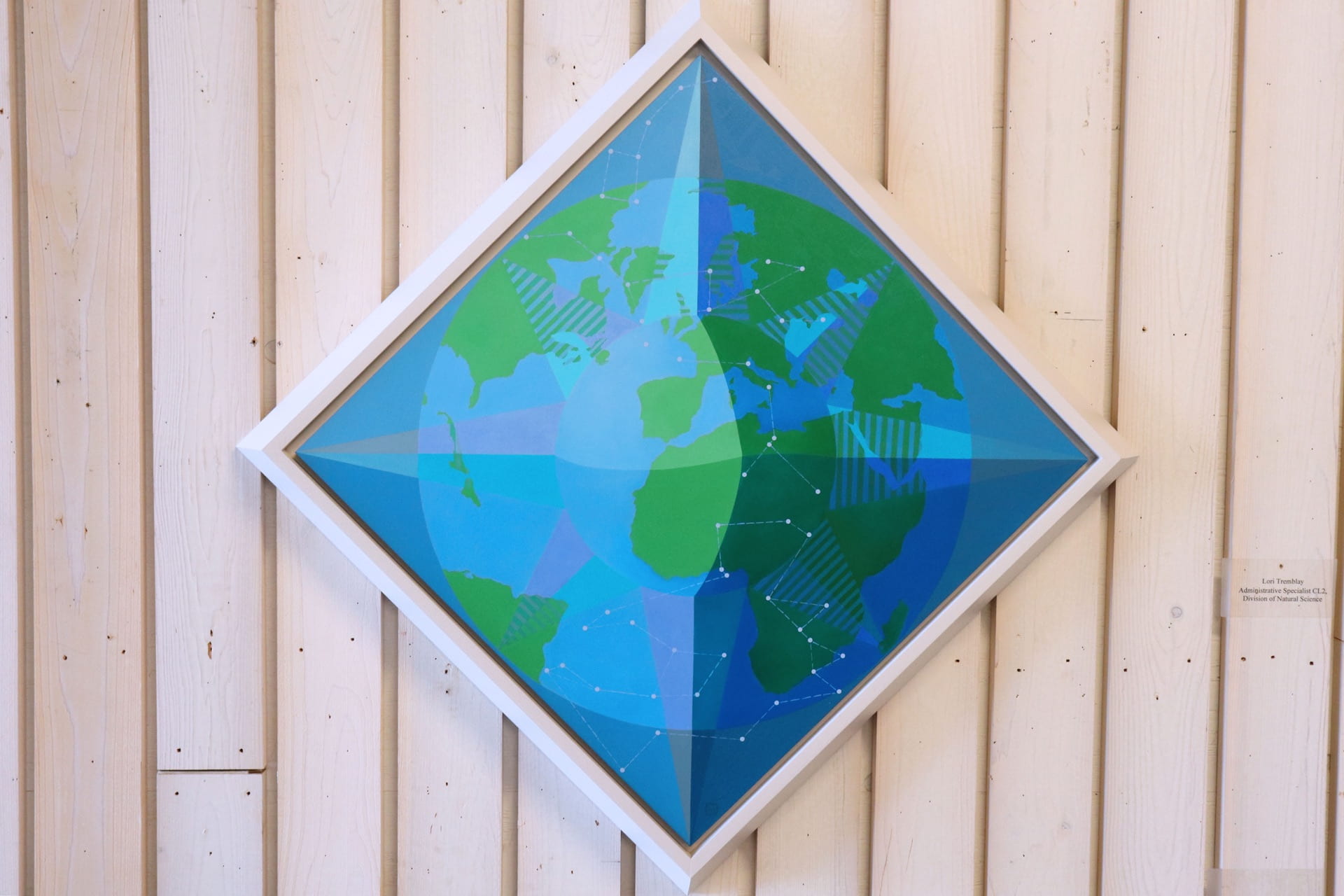 A painting of the Earth embedded in a compass.