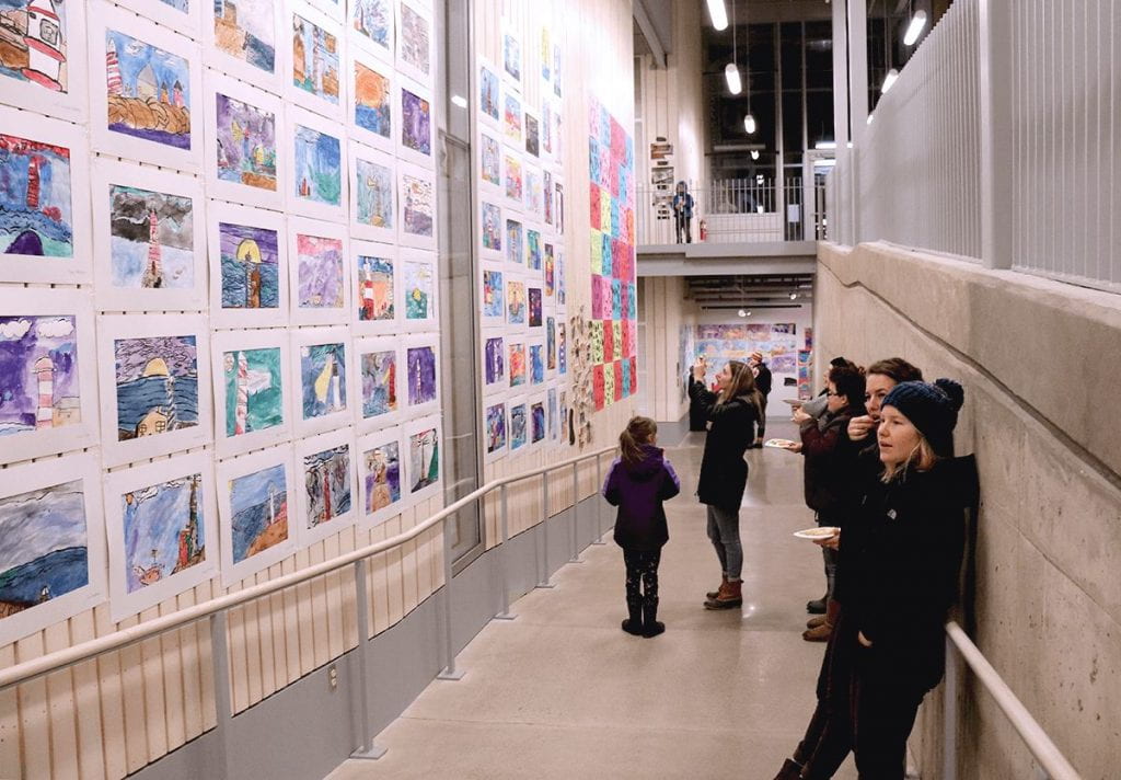 Observers look to student work featuring lighthouses.